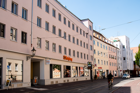 Straßenansicht eines Gebäudes mit Kolping Logo.