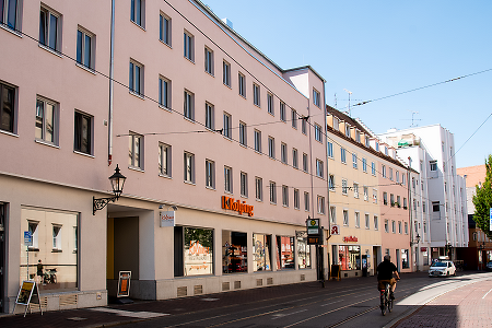 Straßenansicht eines Gebäudes mit Kolping Logo.